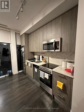Toronto (Church-Yonge Corridor) condo for rent - A modern kitchen with dark wood floors and stainless steel appliances.