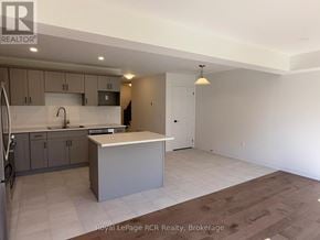 Grey Highlands townhouse for rent - A kitchen with a refrigerator, sink, and cabinets.