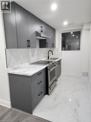 Kitchener apartment for rent - A modern kitchen with a marble countertop and a stainless steel oven.