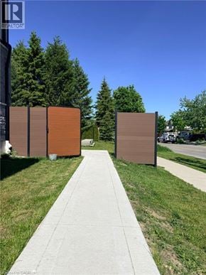 Kitchener apartment for rent - A sidewalk leads to a row of three brown signs.