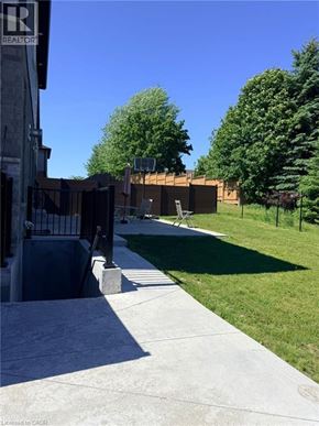 Kitchener apartment for rent - A concrete walkway leads to a building with a sign that says REALTOR.