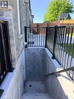 Kitchener apartment for rent - A black metal railing is on the left side of a concrete staircase.