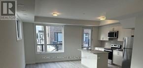 Mississauga (Erin Mills) townhouse for rent - A well-lit kitchen with a refrigerator, microwave, and oven.