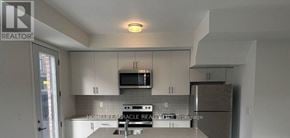 Mississauga (Erin Mills) townhouse for rent - A kitchen with a refrigerator, microwave, and oven.