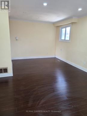 Mississauga (Malton) apartment for rent - A room with a window and a wooden floor.