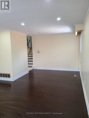Mississauga (Malton) apartment for rent - A room with a staircase in the background and a wooden floor.