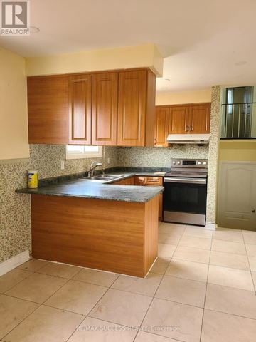Mississauga (Malton) apartment for rent - A kitchen with wooden cabinets and a granite countertop.