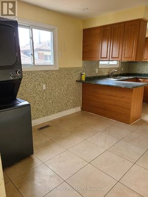 Mississauga (Malton) apartment for rent - A kitchen with a black fridge and a black microwave.