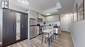 Toronto (Kensington-Chinatown) condo for rent - A well-lit kitchen with a dining table and chairs.