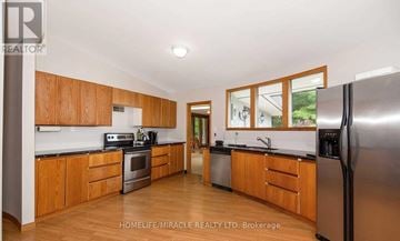 Adjala-Tosorontio apartment for rent - A kitchen with wooden cabinets and stainless steel appliances.