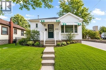 Hamilton apartment for rent - A white house with a green door and a striped awning.
