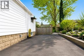 Hamilton apartment for rent - A white house with a driveway and a garden.