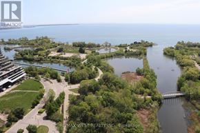 Toronto (Mimico) condo for rent - A bird's eye view of a waterfront property with a bridge and a building in the distance.