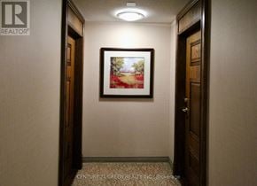 Mississauga (Central Erin Mills) condo for rent - A hallway with a painting on the wall and a brokerage logo in the corner.