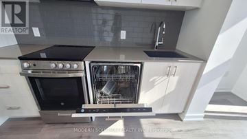Toronto (Islington-City Centre West) condo for rent - A modern kitchen with a stainless steel oven and white cabinets.