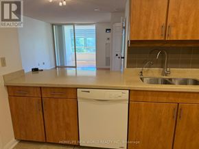 Toronto (Newtonbrook West) condo for rent - A kitchen with wooden cabinets and a white dishwasher.