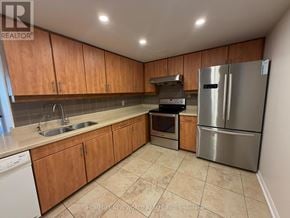 Toronto (Newtonbrook West) condo for rent - A kitchen with wooden cabinets and a stainless steel refrigerator.
