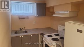 Toronto (Clairlea-Birchmount) apartment for rent - A small kitchen with a stove, sink, and cabinets.
