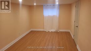 Toronto (Clairlea-Birchmount) apartment for rent - A room with wooden flooring and a window with white curtains.