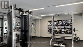 Toronto (Newtonbrook East) condo for rent - A gym with a variety of equipment including a squat rack, a bench, and a barbell.