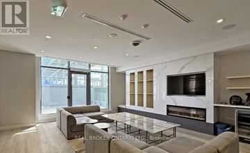 Toronto (Newtonbrook East) condo for rent - A modern living room with a grey sofa and a glass coffee table.