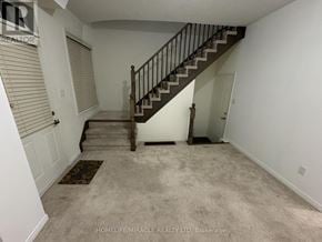 Ajax (Central) townhouse for rent - A spacious room with a staircase leading to the upper floor.