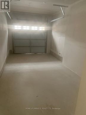 Ajax (Central) townhouse for rent - A spacious garage with a white wall and a closed white door.