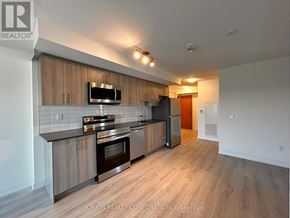 Pickering (Bay Ridges) condo for rent - A modern kitchen with wooden cabinets and stainless steel appliances.