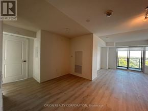Pickering (Bay Ridges) condo for rent - A spacious room with wooden flooring and a large window overlooking the outdoors.