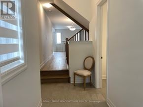 Milton (Bw Bowes) townhouse for rent - A chair sits in a hallway with a staircase in the background.
