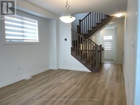 Milton (Bw Bowes) townhouse for rent - A well-lit room with a wooden staircase and a window with blinds.