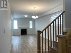 Milton (Bw Bowes) townhouse for rent - A large, empty room with a fireplace and wooden stairs.
