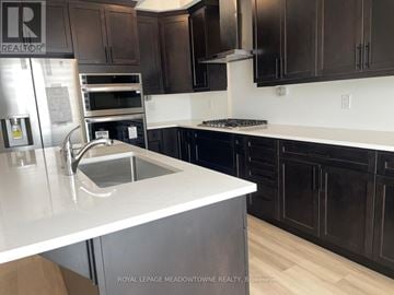 Milton (Bw Bowes) townhouse for rent - A modern kitchen with dark brown cabinets and a white countertop.