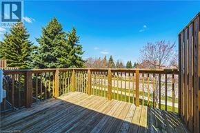 Hamilton townhouse for rent - A wooden deck with a railing and trees in the background.