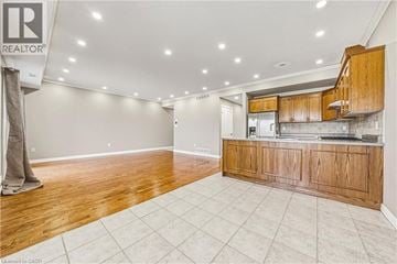 Hamilton townhouse for rent - A spacious kitchen with wooden cabinets and a tiled floor.