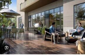 Kitchener condo for rent - A group of people are sitting and standing on a patio outside a building.