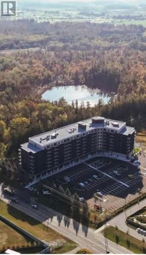 Kitchener condo for rent - A large building with a parking lot in front of it.