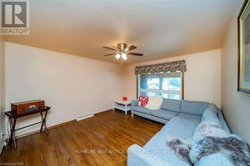 Niagara Falls (Dorchester) apartment for rent - A living room with a grey couch and a ceiling fan.