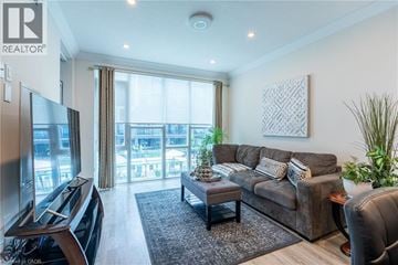 Grimsby condo for rent - A living room with a brown couch and a television.