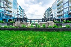 Grimsby condo for rent - A grassy area in front of apartment buildings with a bridge in the background.
