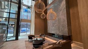 Toronto (Church-Yonge Corridor) condo for rent - A modern interior space with wooden furniture and hanging light fixtures.