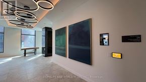 Toronto (Church-Yonge Corridor) condo for rent - A modern office space with a bench, a painting, and a yellow sign on the wall.