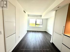 Toronto (North St. James Town) condo for rent - A spacious room with wooden flooring and white walls.