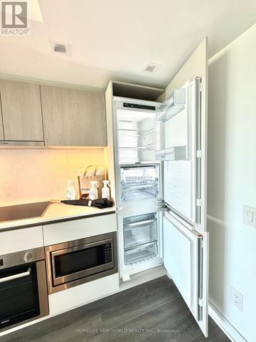 Toronto (North St. James Town) condo for rent - A kitchen with a refrigerator, oven, and microwave.