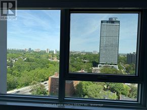 Toronto (North St. James Town) condo for rent - A view of a cityscape from a window with a tall building in the background.