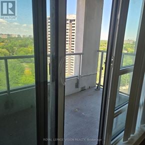 Toronto (Henry Farm) condo for rent - A view from inside a building looking out through a window at a cityscape.