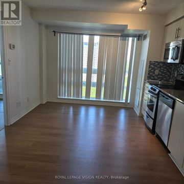 Toronto (Henry Farm) condo for rent - A kitchen with white cabinets and a wooden floor.