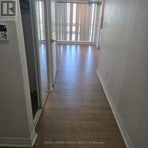 Toronto (Henry Farm) condo for rent - A hallway with a door on the left and a balcony on the right.