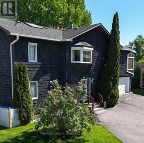 Ramara (Brechin) apartment for rent - A house with a grey exterior and a white garage door.