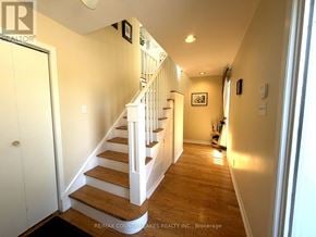Ramara (Brechin) apartment for rent - A hallway with a staircase and a brokerage sign.